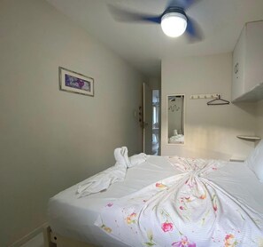 A hotel room with a bed, a ceiling fan, a mirror, and a framed picture on the wall. - Condomínio Merepe Residence (Ipojuca)