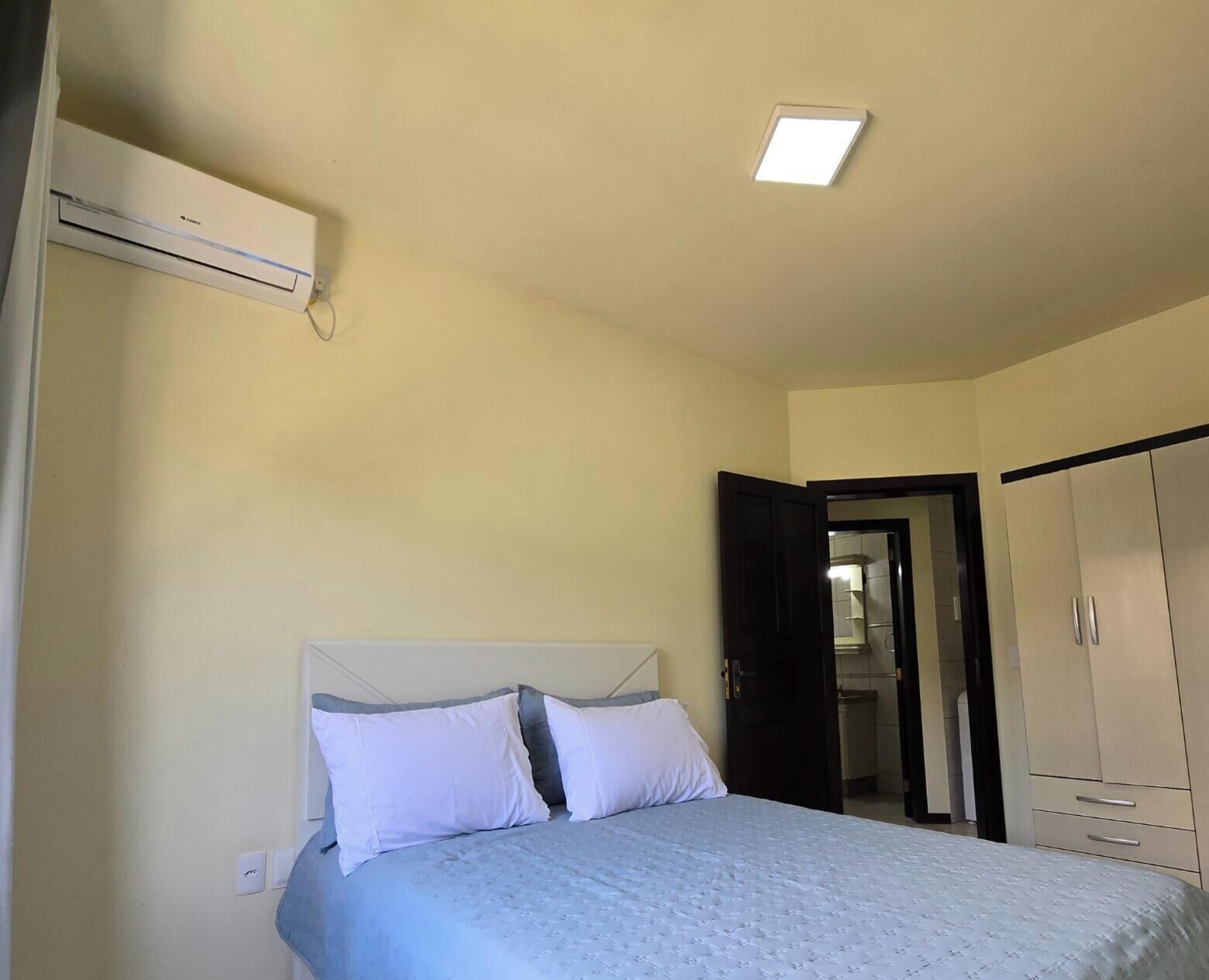 Ein Schlafzimmer mit einem Bett, einem Kleiderschrank und einer Deckenleuchte.