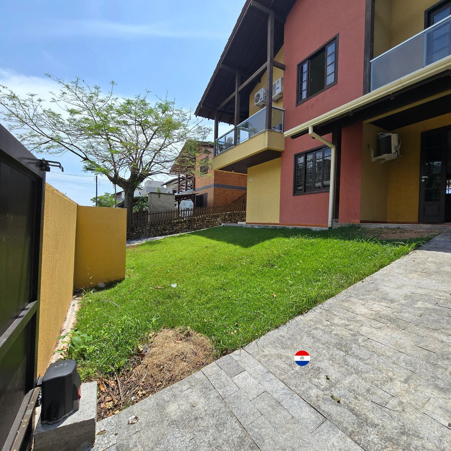 Un edificio residencial con un césped cuidado y un camino pavimentado.