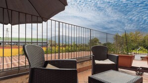 A balcony with wicker furniture and a view of a sports field. - Fabiola Guest House (Pompei)