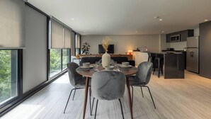 A modern kitchen with a dining area, large windows, and a minimalist design. - Suave Polanco Exclusive - Modern 2-bedroom Apartment in Polanco (Mexico City)