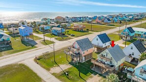Zona residencial costera con casas, una calle y una playa al fondo.