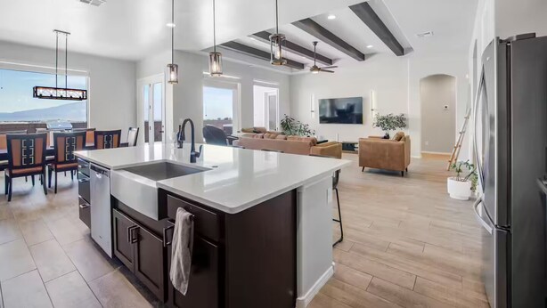 A modern kitchen with a large island, dark cabinetry, and pendant lighting. - 4-bedroom + Hot tub + Firepit + Sandia views (Rio Rancho)