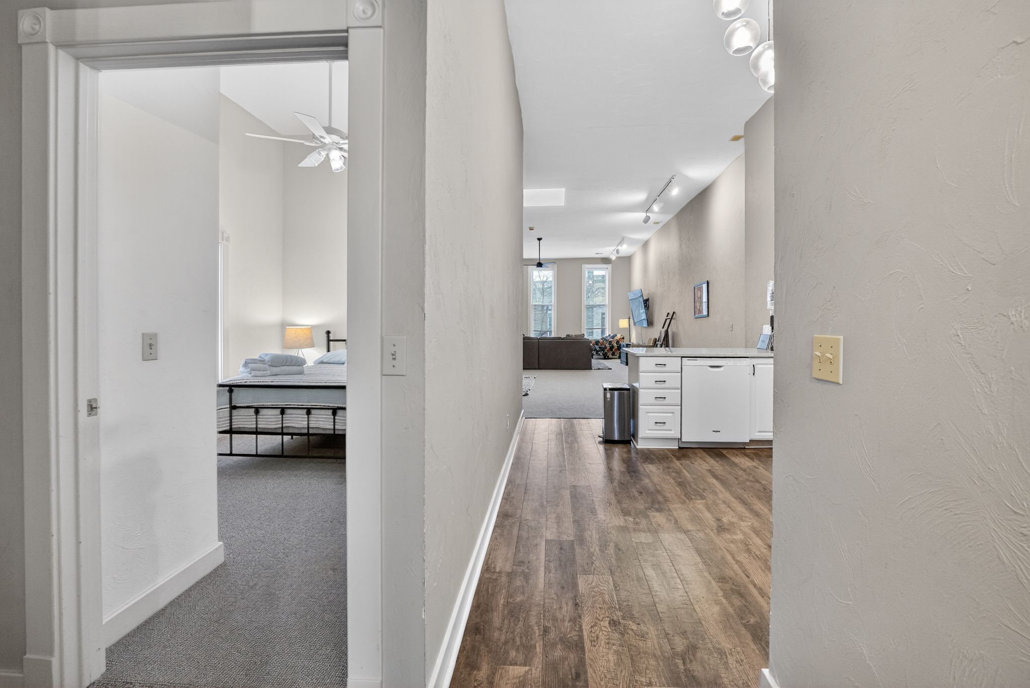 A hotel room with a bed, a desk, and a kitchenette.
