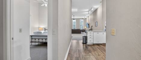 A hotel room with a bed, a desk, and a kitchenette.