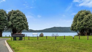 A park with picnic tables and a sign for Gisborne Point Reserve. - Rotoiti Escape - Lake Rotoiti Holiday Home (RD 4)