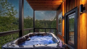 A hot tub on a wooden deck with a starry night sky view. - Peaceful Paradise (Sevierville)