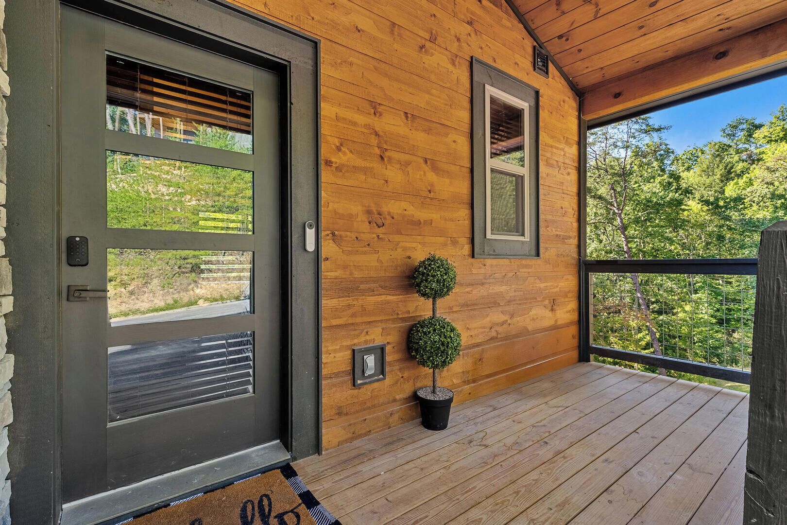 A wooden exterior with a door, windows, and a small potted plant.