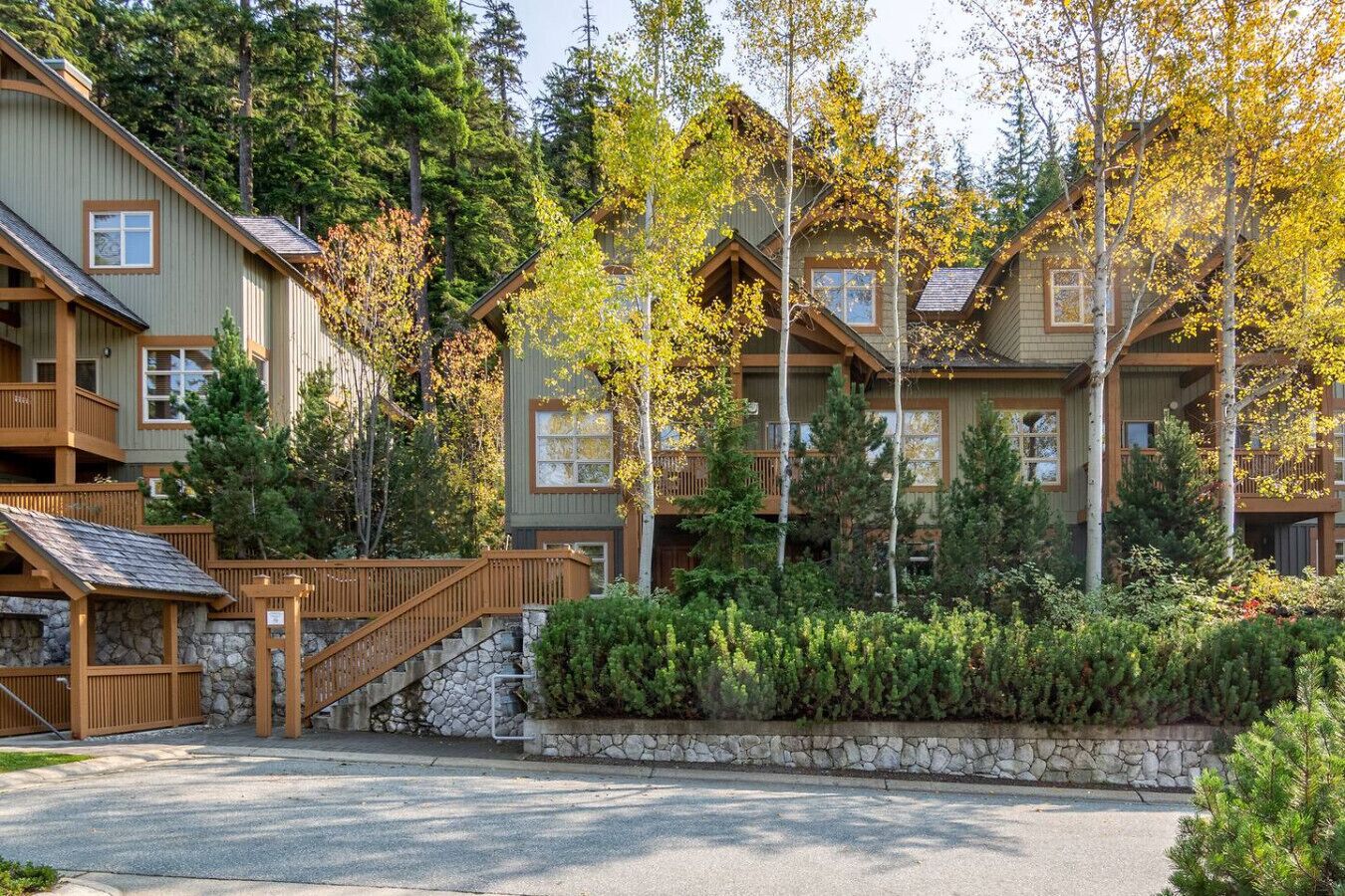 A lodge with multiple wooden balconies, stone staircases, and a stone retaining wall.