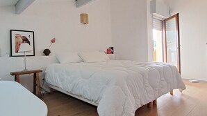 A bedroom with a large bed, a bedside table, a lamp, and a framed picture on the wall. - Charming house in Biscarrosse with terrace and parking (Biscarrosse Plage)