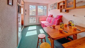 Una habitación acogedora con una mesa de madera, un sofá y una ventana con vistas.