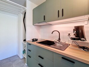A compact kitchen with a sink, a coffee machine, and a bowl on the countertop. - Bright studio with south-facing balcony at the foot of the slopes (Val Thorens)
