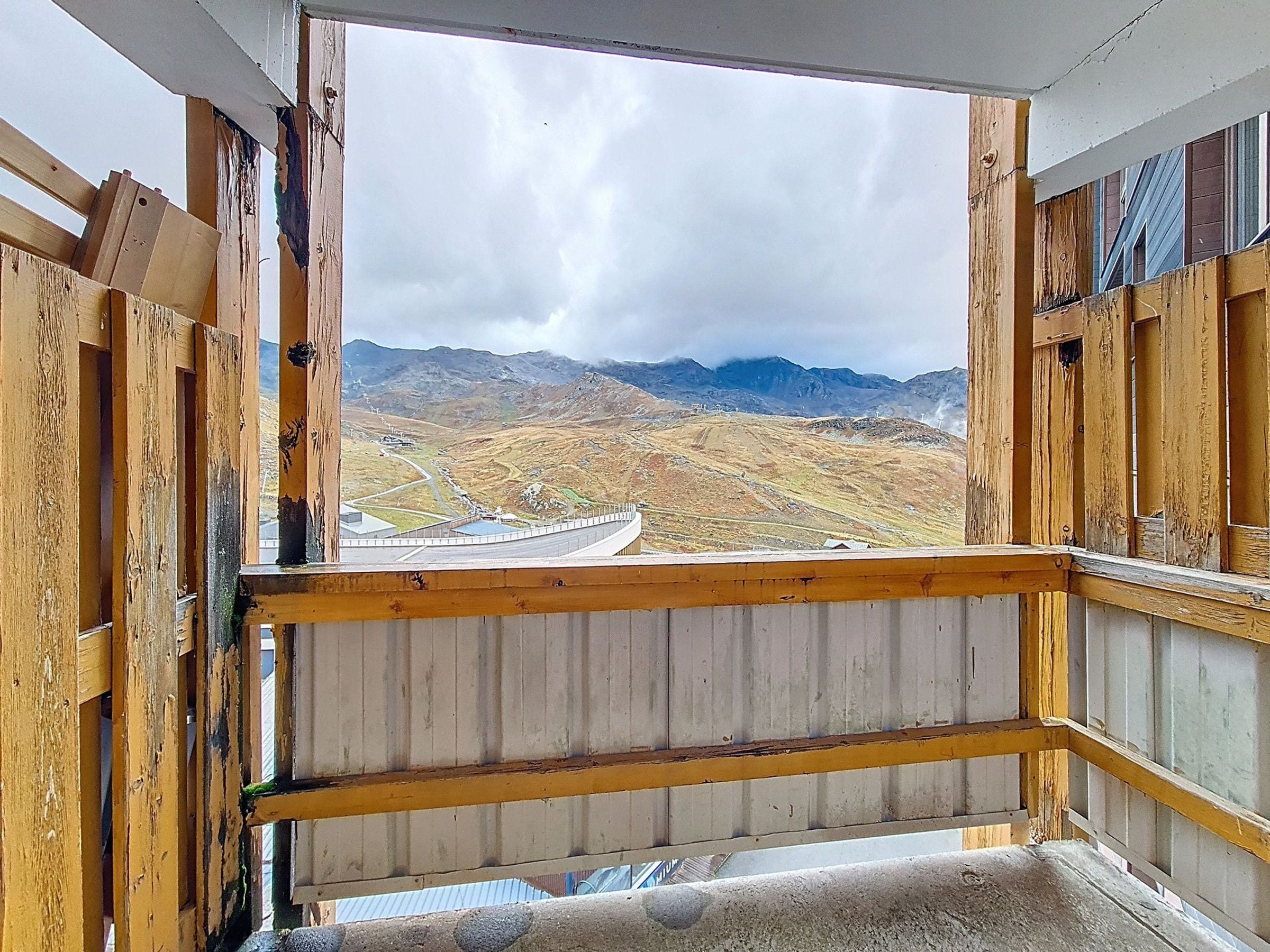 A room with a view of a mountainous landscape through a window.