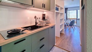 Ett modernt kök med en inbyggd spis, ett handfat och en matplats med ett bord och stolar.