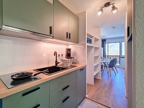 Eine moderne Küche mit Einbauherd, Spüle und Essbereich mit Tisch und Stühlen.