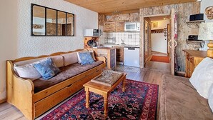 Een gezellige woonkamer met een houten bank, een salontafel en een kamerkleed met een patroon.