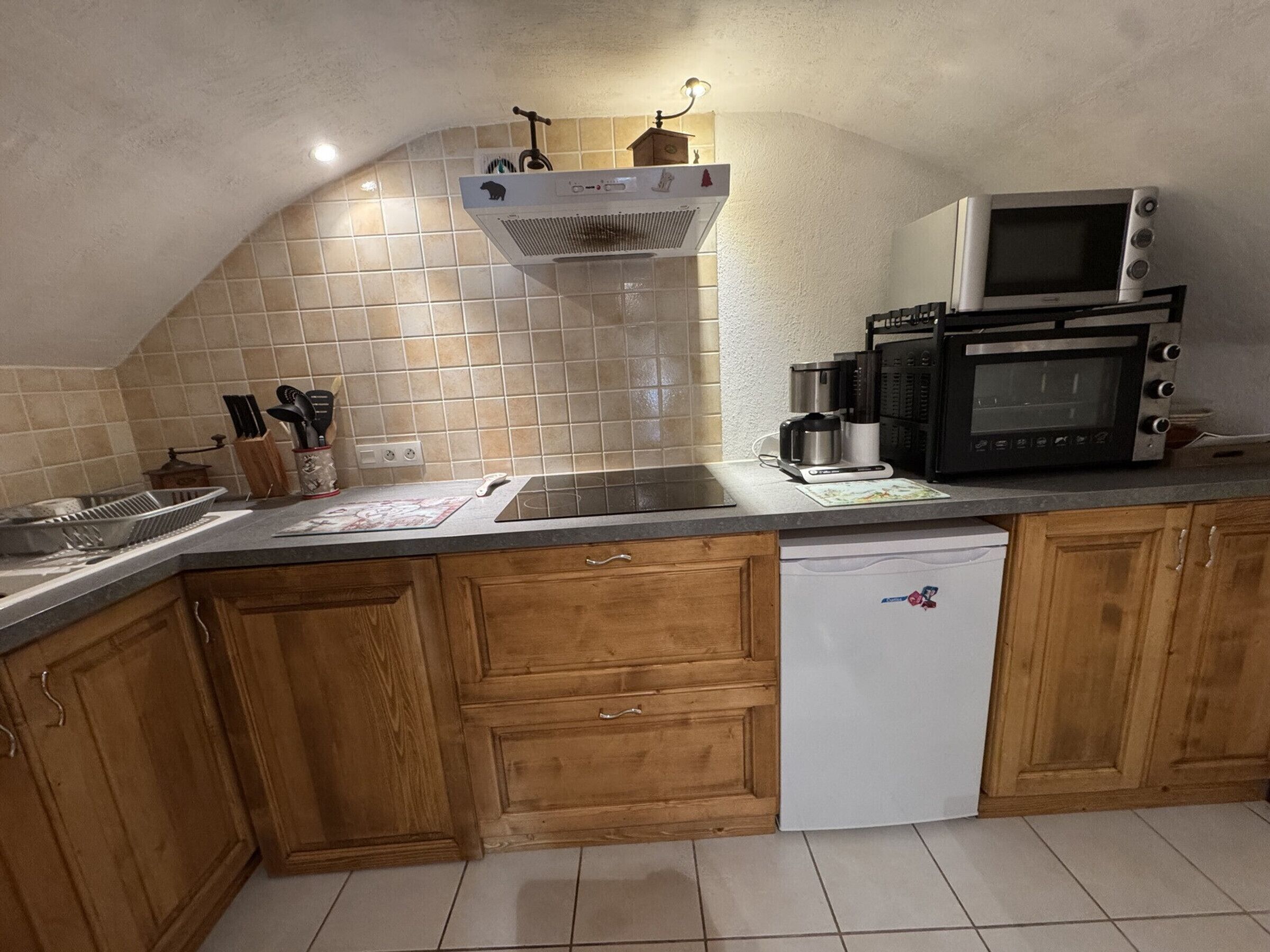 A kitchen with wooden cabinets, a dishwasher, a sink, and two microwaves.