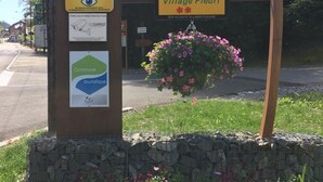 Een bord met verschillende informatieborden, waaronder een voor 'LES CARROZ commune d'ARACHES' en een ander voor 'Village Fleuri'.