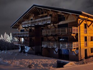 A wooden chalet with a balcony and a ski lift visible in the background. - Modern 2-bedroom Apartment, WIFI & Parking, Arâches-la-Frasse (Arâches-la-Frasse)