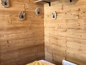 A wooden cabin interior with a bed, a small table, and a wall-mounted shelf. - 2-room apartment at cable car base, pets allowed, parking (Arâches-la-Frasse)