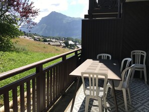 A balcony with a table and chairs overlooking a mountainous landscape. - 2-room apartment at cable car base, pets allowed, parking (Arâches-la-Frasse)