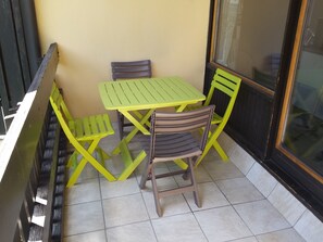 Ein kleiner Außenbereich mit Tisch und zwei Stühlen.