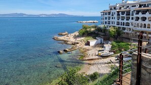 A coastal building with clear views of the sea and distant mountains. - Comfortable apartment with terrace, central, near the beach (L'Escala)