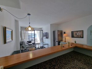 Uma cozinha moderna com bancada de madeira, geladeira e área de refeições com mesa e cadeiras.