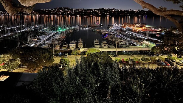 Una marina iluminada por luces con barcos amarrados por la noche.