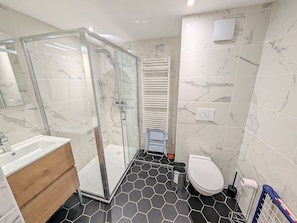 A modern bathroom with a glass shower enclosure, a white toilet, and a wooden vanity. - Stunning new apartment 8 pers, 55m² south terrace, near slopes (Montgenèvre)
