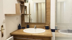 A bathroom with a wooden vanity, a white sink, and a mirror. - Studio ski-in/ski-out with large balcony at Les Orres (Les Orres)