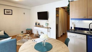 A compact living space with a dining area, kitchenette, and a TV mounted on the wall. - Studio ski-in/ski-out with large balcony at Les Orres (Les Orres)