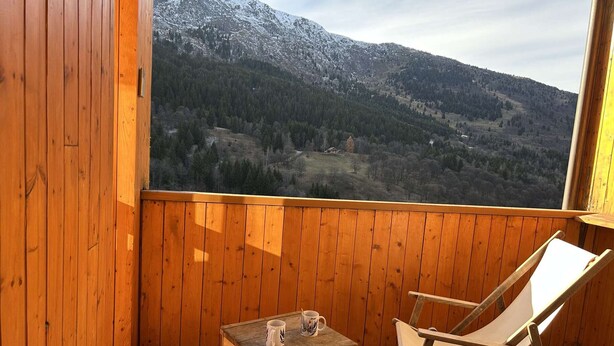 A wooden balcony with two chairs and a small table, overlooking a mountainous landscape. - 3-Room Alcove Apartment for 6 in Méribel, near shops (Méribel)