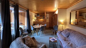 A cozy cabin interior with a dining area, a sofa, and a small table. - 3-Room Alcove Apartment for 6 in Méribel, near shops (Méribel)
