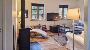 A cozy living room with a sofa, a coffee table, a TV, and a fireplace. - 3 bedroom cozy home in Vrå (Vrå)