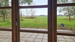 A room with a large window overlooking a grassy field and trees. - 3 bedroom cozy home in Vrå (Vrå)