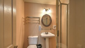 A bathroom with a toilet, sink, and shower. - The Russell Room at The Historic Eureka Inn and Event Center (Jonesborough)