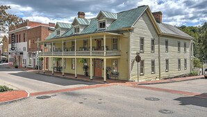 A historic building with a balcony and a porch, featuring a brick facade and a green roof. - Angeline's Room at The Historic Eureka Inn and Event Center (Jonesborough)