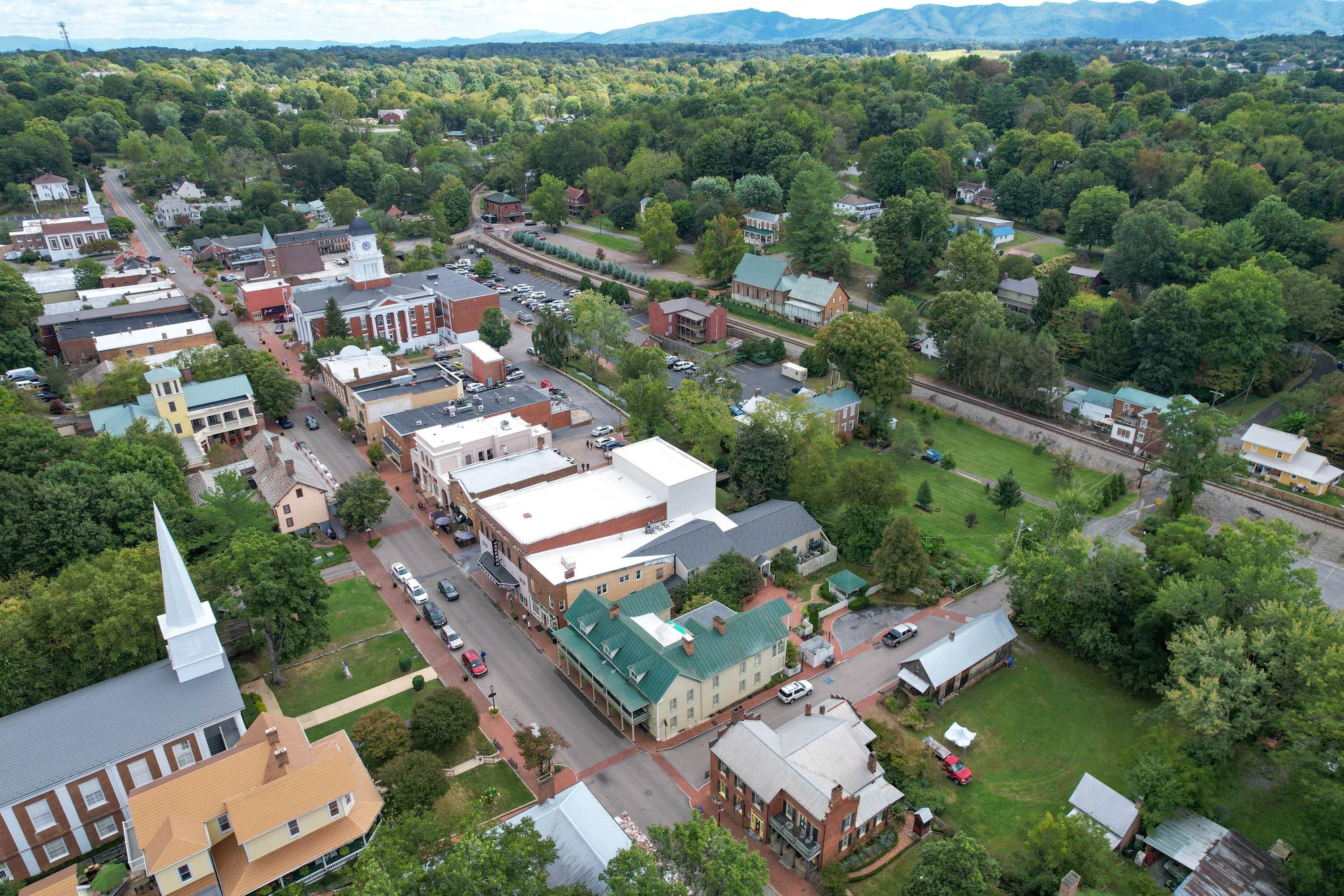 An aerial view of a town with historic buildings, a church, and a railway track.