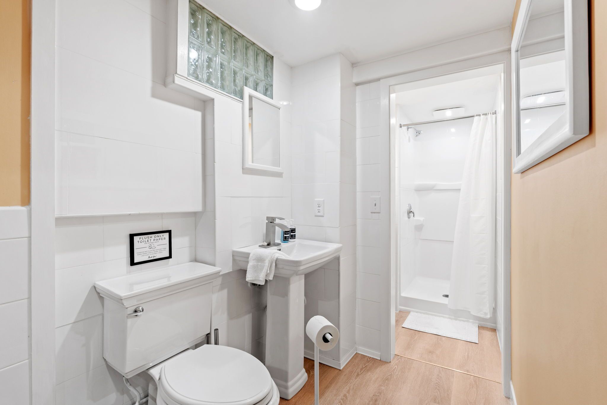 Un bagno piccolo e pulito, con il water, il lavandino e la doccia.