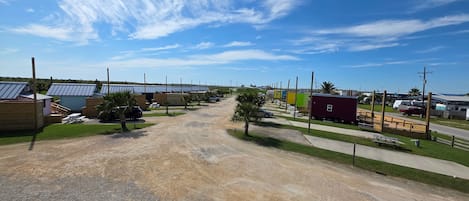 Ein Campingplatz mit Wohnmobilen und Reisemobilen, Kieswegen und blauem Himmel.