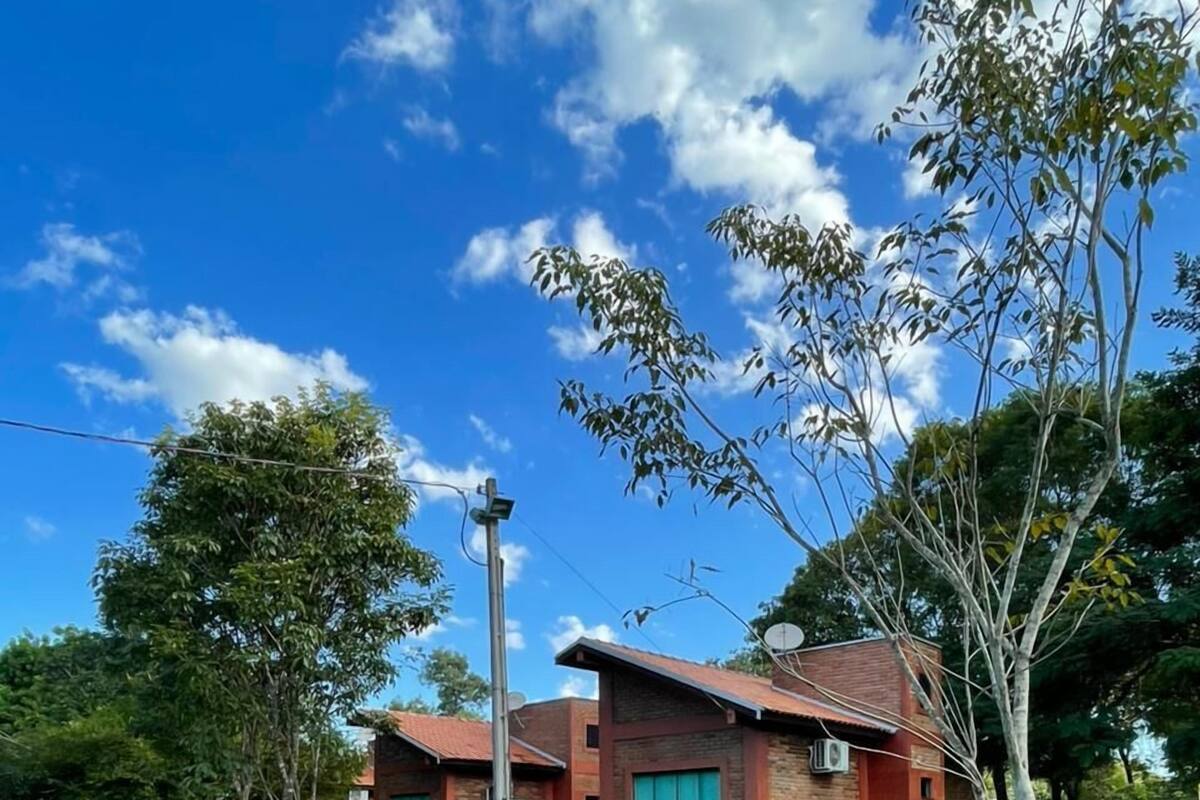 A two-story brick building with a flat roof, surrounded by a well-maintained lawn and trees.