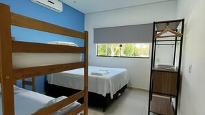 A room with bunk beds, a hanging chair, a window, and an air conditioning unit.