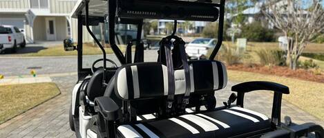Un carrito de golf con asiento a rayas negras y blancas, un toldo de la marca BINTELLI, y una vista posterior del diseño del carrito.