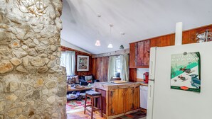 Een landelijke keuken met houten kastjes, een stenen muur en een koelkast met een magneet met ski-thema.
