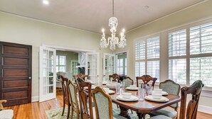 Comedor con una mesa de madera dispuesta para seis personas, rodeado de sillas tapizadas.