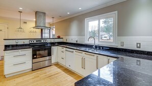 A modern kitchen with white cabinets, a black countertop, and a stainless steel oven. - Serene & Spacious! Family-Friendly Catharpin Home (Catharpin)