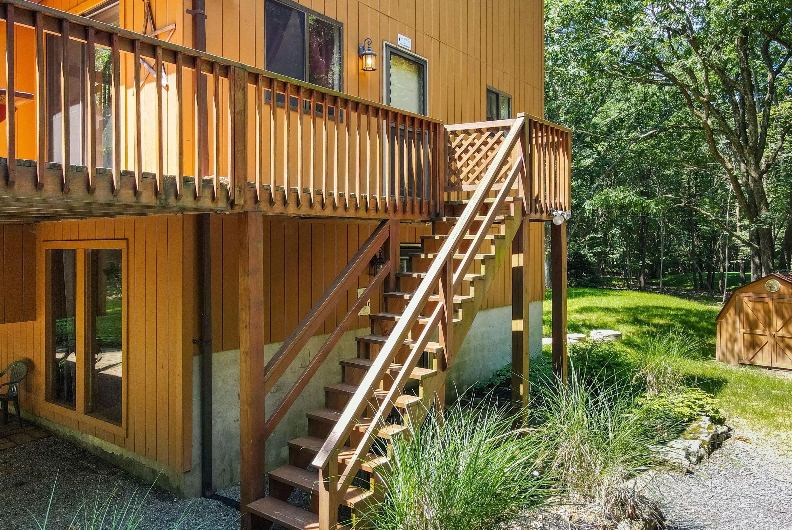 A wooden building with a wooden staircase leading to a balcony.