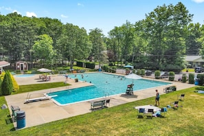 A swimming pool with a surrounding deck, lounge chairs, and a covered area. - 5BR Poconos Cabin Near Jim Thorpe, Sleeps 10 (Jim Thorpe)