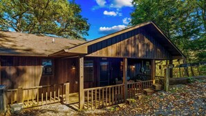 A rustic cabin with a wooden exterior, a porch, and a gravel driveway. - Wears Valley 3BR Retreat - Hot Tub, Multicade, Pool Table & Hoops! (Sevierville)